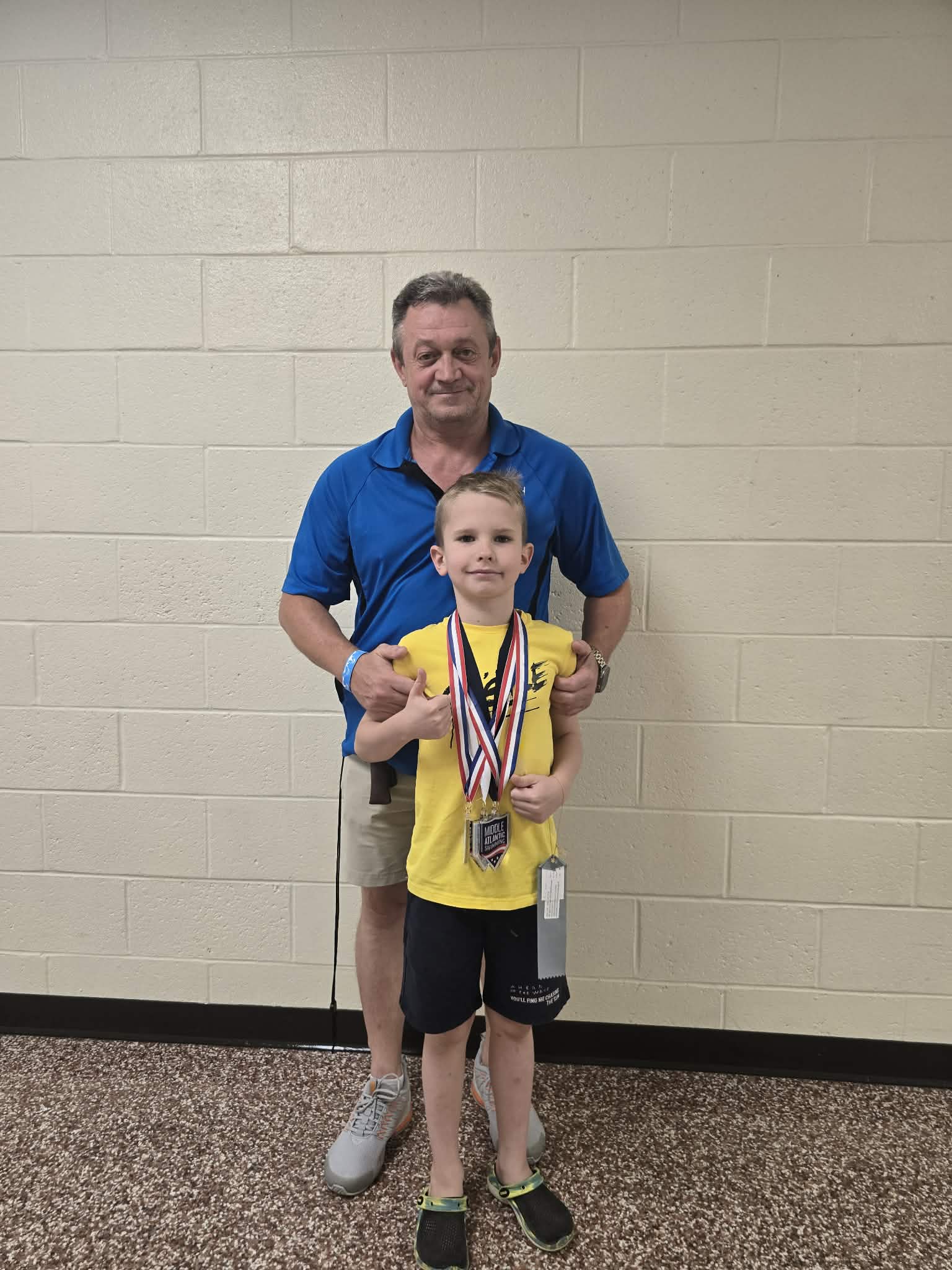 Coach Vitaliy with a young medal-winning swimmer